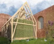 On the eastern side is a staircase surrounded by wooden beams overgrown with vines