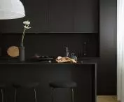 Czarny aneks kuchenny i wyspa z delikatnym blatem