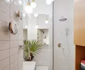 On the wall in the bathroom are mounted Pin Copper decorations designed by Oskar Zięta 