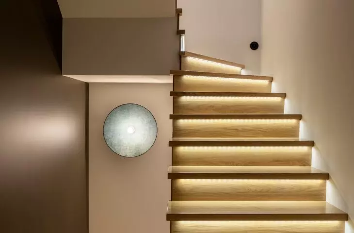 The staircase is illuminated by colored lamps