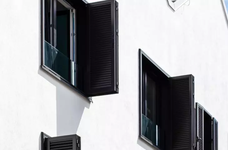Black shutters contrast with white plaster