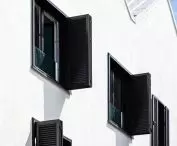 Black shutters contrast with white plaster