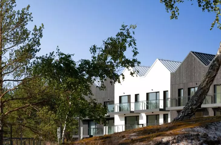 The facade is made of tan wood and white plaster